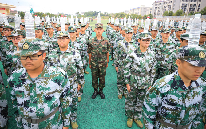 9月2日,在湖南省衡阳市南华大学雨母校区,李俊(中)头顶水瓶与同学们一道站军姿 9月2日,在湖南省衡阳市南华大学雨母校区,李俊(中)头顶水瓶与同学们一道站军姿